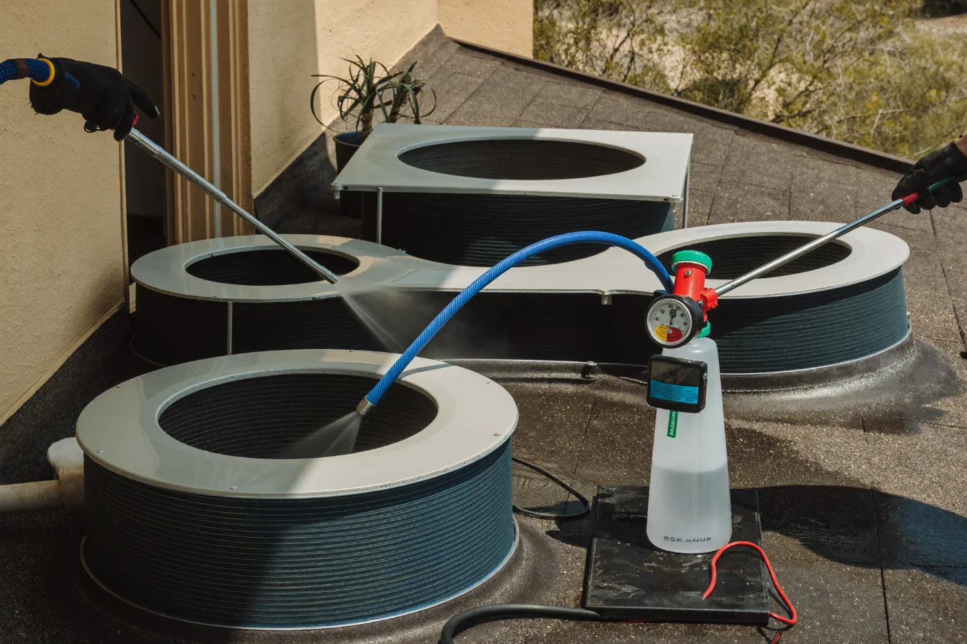 Air conditioning condenser coils being cleaned on a villa rooftop