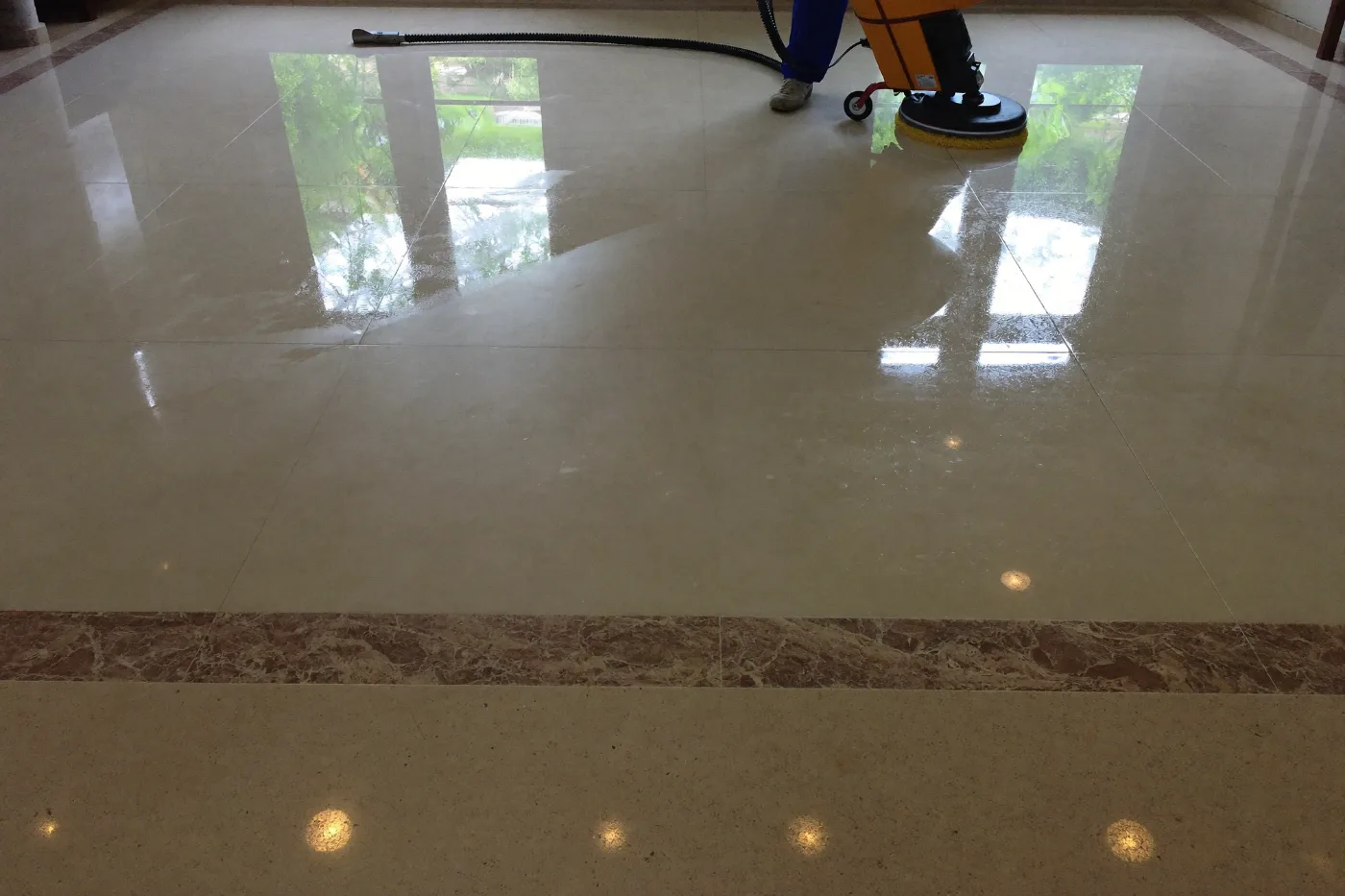 Floor scrubbing machine polishing a marble tiled villa floor