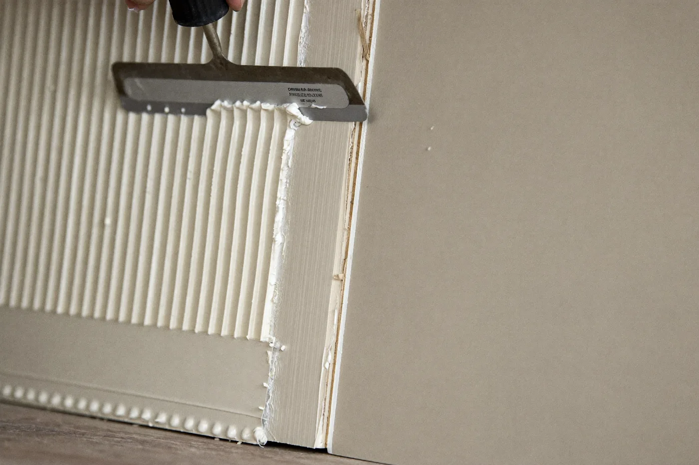 Gypsum board joint being taped and skimmed with a taping knife