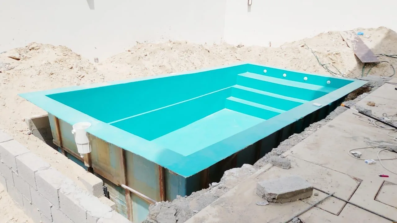 Installed fiberglass pool shell with moulded steps and blockwork surround