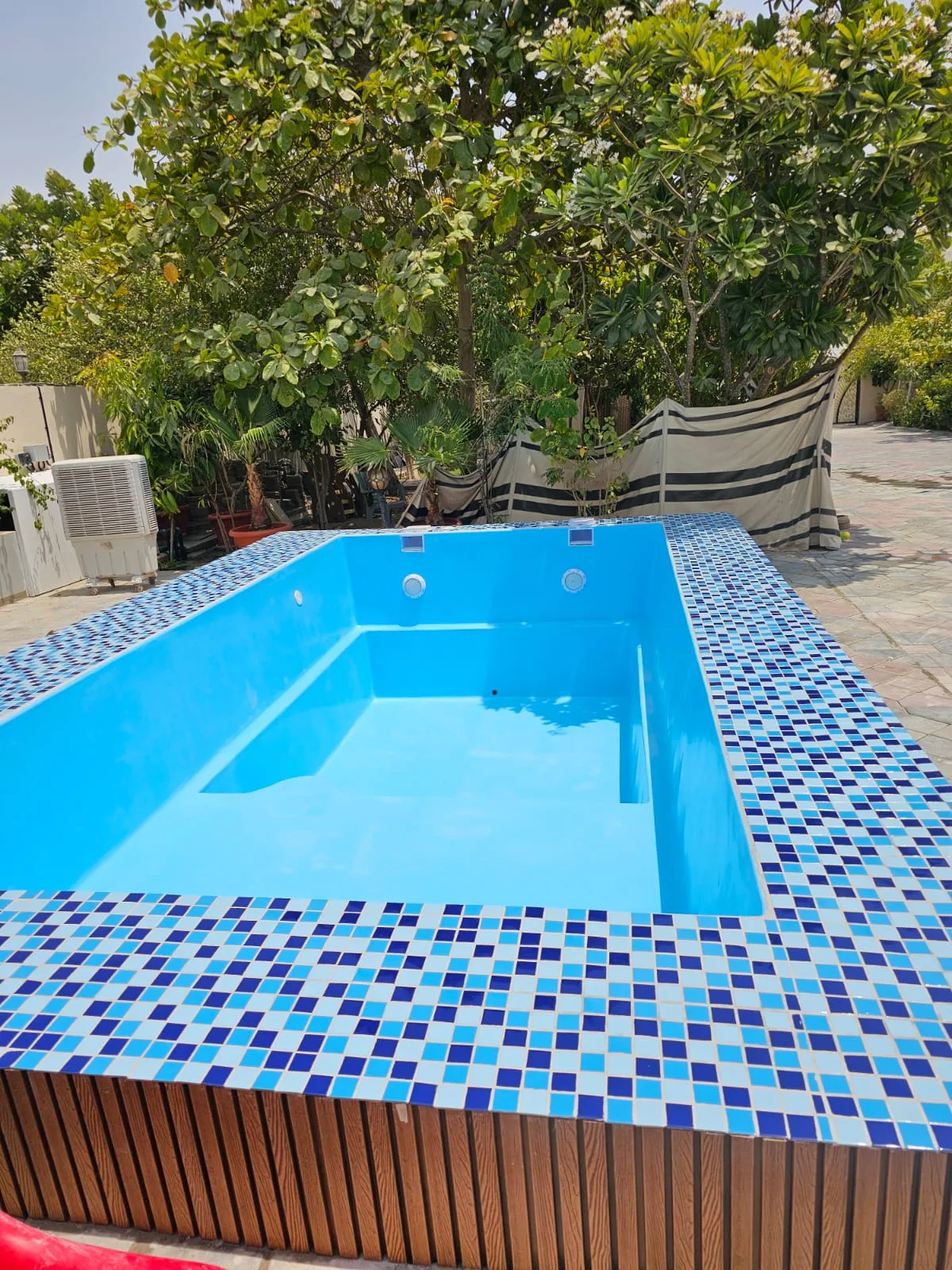 Finished villa pool with mosaic coping and a timber deck surround