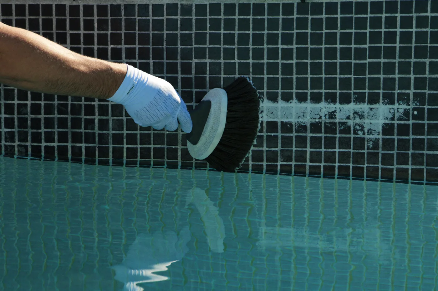 Waterline mosaic tiles being scrubbed clean of mineral scale